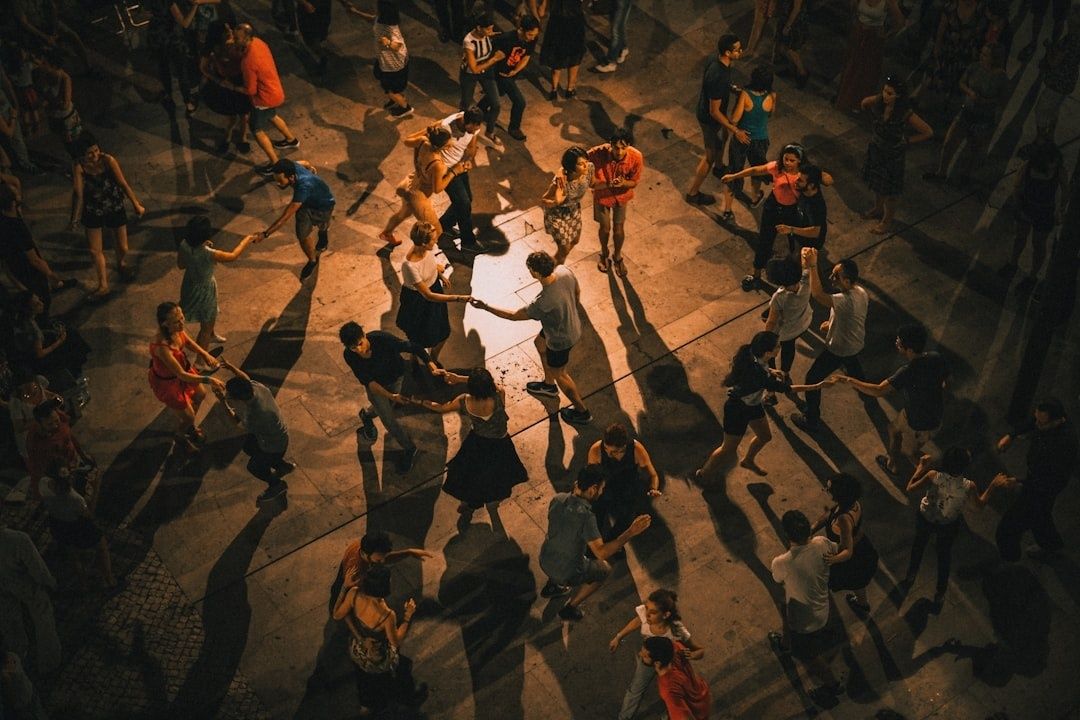 Diverse crowd dancing together outdoors under warm evening light